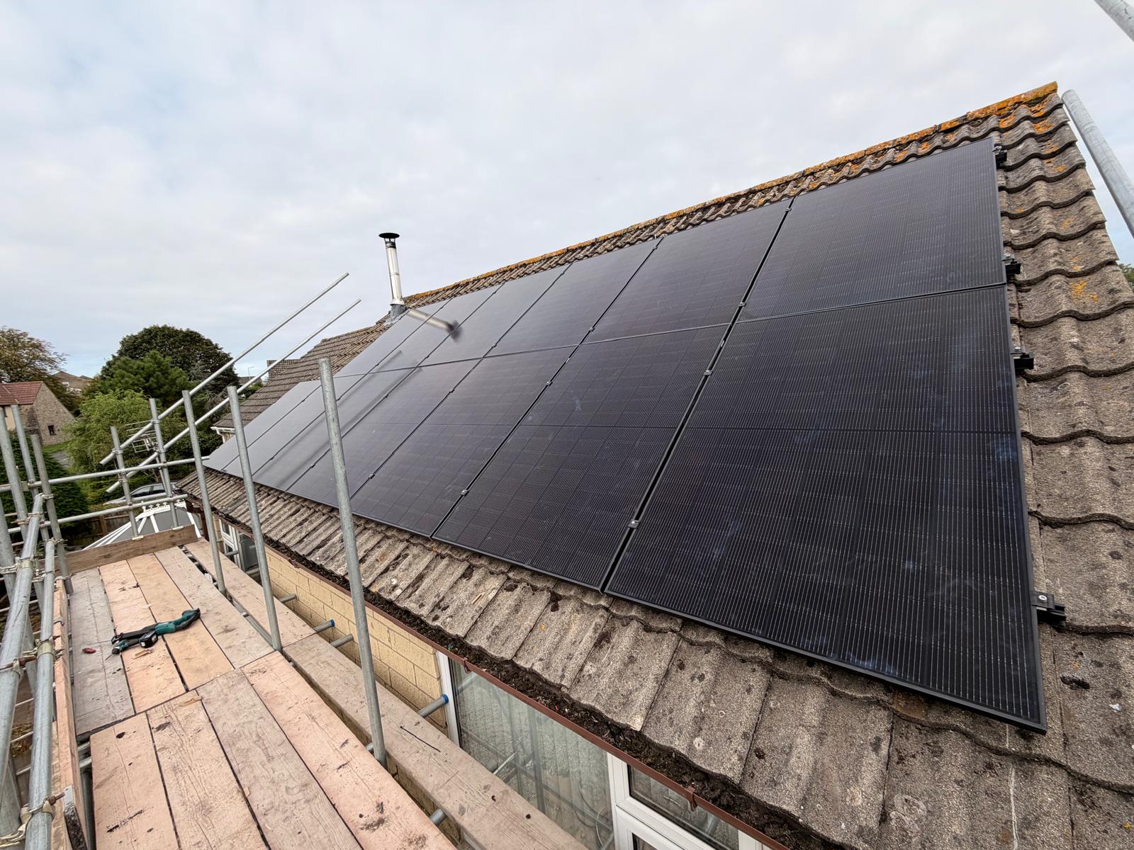 Eight solar panels newly fitted on a concrete pantile roof