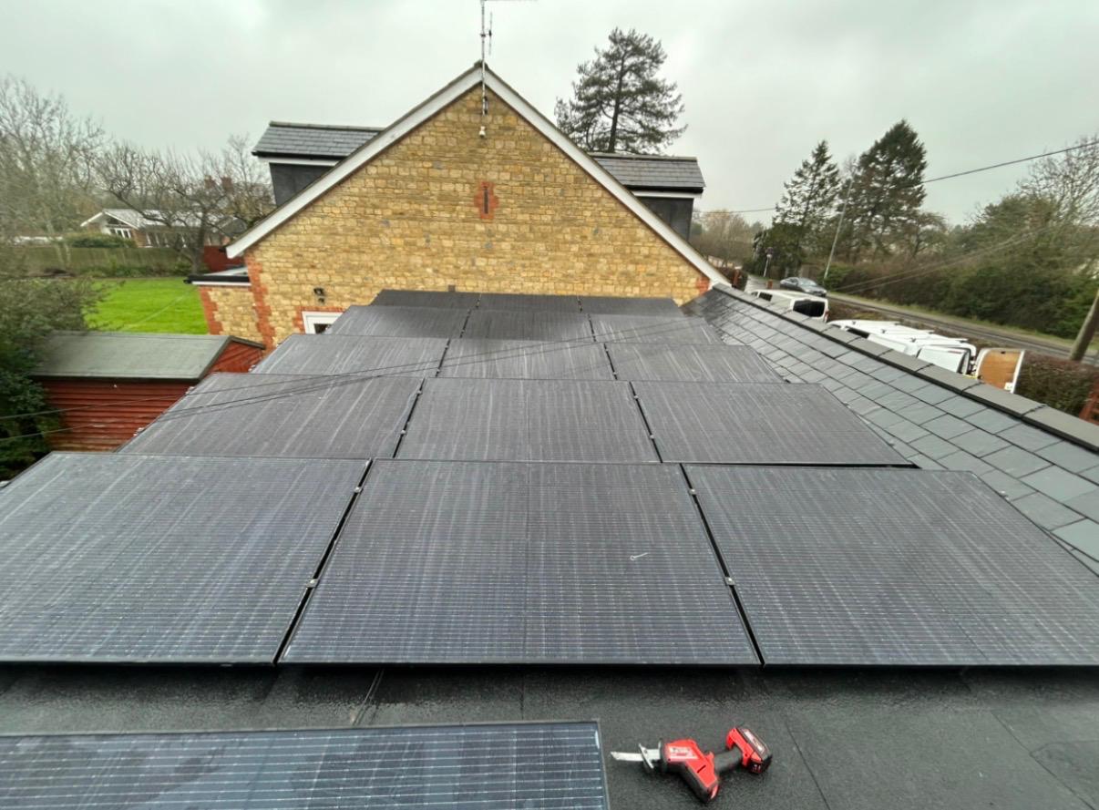 Black solar panels mounted on a slate and flat roof